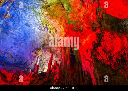 Prometheus Cave Natural Monument, Kutaisi, Georgia, mit hängenden Steinvorhängen, Stalaktiten und Stalagmiten, bunt beleuchteten Felsformationen. Stockfoto