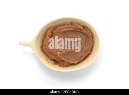 Verschmiertes Kastanienpüree in einer Schüssel isoliert auf weiß. Marronencreme, Marronenaufstrich, castanea-Marmelade, hausgemachte Kastanien-Dessert-Pfütze, Beize, Tropfen. Stockfoto