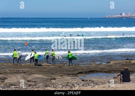 Surfer surfen an der felsigen Küste, Playa de las Américas, Teneriffa, Kanarische Inseln, Königreich Spanien Stockfoto