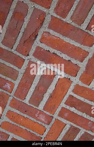 Nahaufnahme der Backsteinwand mit Kreuzschraffurmuster. Aus einem alten Gebäude in Neuengland. Foto aus einem Winkel aufgenommen. Stockfoto