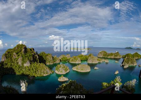 Inseln mit Kalksteinspitzen und Tauchbooten an Bord, Penemu Aussichtspunkt, in der Nähe von Waigeo Island, Raja Ampat, Indonesien Stockfoto