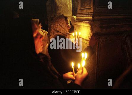 Hunedoara County, Rumänien, 2002. Gläubige mit brennenden Kerzen während des Gottesdienstes in der christlich-orthodoxen Kirche Densus. Stockfoto