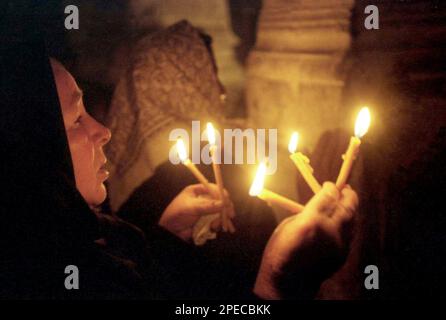 Hunedoara County, Rumänien, 2002. Gläubige mit brennenden Kerzen während des Gottesdienstes in der christlich-orthodoxen Kirche Densus. Stockfoto