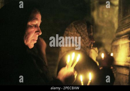 Hunedoara County, Rumänien, 2002. Gläubige mit brennenden Kerzen während des Gottesdienstes in der christlich-orthodoxen Kirche Densus. Stockfoto