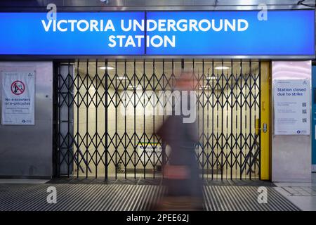 London, Großbritannien. 15. März 2023. Eine Person passiert die geschlossenen Tore außerhalb der Victoria U-Bahn Station während der Hauptverkehrszeit. Ein 24-stündiger Streik von Mitgliedern der Aslef- und RMT-Gewerkschaften, die den Londoner U-Bahn-Dienst (TfL) geschlossen haben, was einen Nebeneffekt durch eine Zunahme des Straßenverkehrs und auch Überbelegung von Bussen und S-Bahnen verursachte. Kredit: Elfte Stunde Fotografie/Alamy Live News Stockfoto