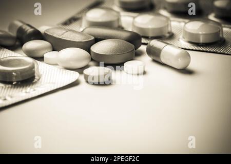 Verschüttete Sepia farbige Pillen von offenen verschreibungspflichtigen Medikamenten Kunststoff gelber brauner Hintergrund Stockfoto