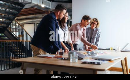 Team von Fachleuten, die Geschäftsideen in einer Marketingagentur diskutieren. Gruppe von Geschäftsleuten, die ein Brainstorming in einem Meeting durchführen. Geschäftsleute wor Stockfoto