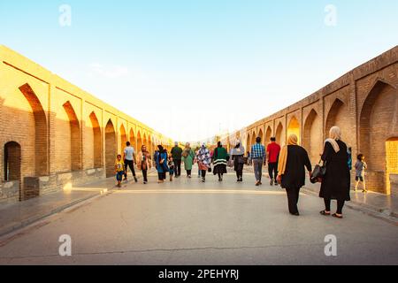 Isfahan, Iran - Mai 2022: Menschen gehen auf Sio SE Pol oder Brücke mit 33 Bögen, eine der ältesten Brücken von Esfahan und die längste Brücke am Zayandeh River Stockfoto