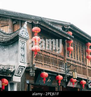 Traditionelles chinesisches Haus mit roten Laternen an der Fassade Stockfoto