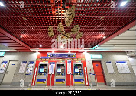 Ticketautomaten an der MRT-Station Wat Mangkon, Bangkok, Thailand, mit kunstvoll verziertem Drachenrelief an der Decke Stockfoto