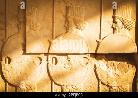 Persepolis, Iran - 8. juni 2022: Mit persischen Soldaten geschnitzte Steine in der berühmten Ausgrabungsstätte von Persepolis Stockfoto