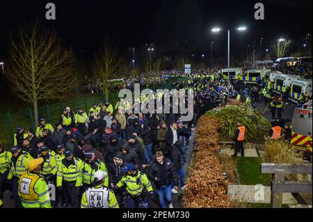 Die Polizei eskortiert Palace-Fans ins Stadion, während sie sie vor dem Spiel der Premier League zwischen Brighton & Hove Albion und Crystal Palace im American Express Community Stadium, Brighton, Großbritannien, vom 15. März 2023 fernhalten. Foto: Simon Dack/Teleobjektiv. Stockfoto