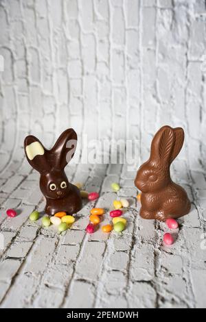Nahaufnahme einer festlichen Ostervorstellung mit einem Schokoladenhasen und bunten, mit Süßigkeiten gefüllten Eiern nebeneinander angeordnet Stockfoto