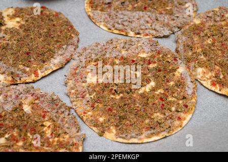 Verzehrfertiger gefrorener Lahmacun auf Backpapier auf einem Backblech Stockfoto