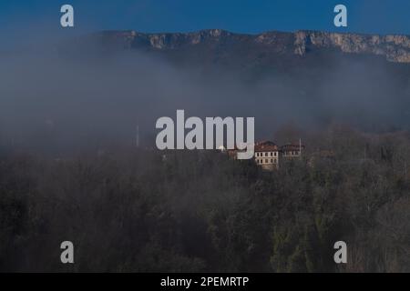 Häuser auf der Talseite und Berge dahinter an einem nebligen Tag, Karabuk, Türkei Stockfoto