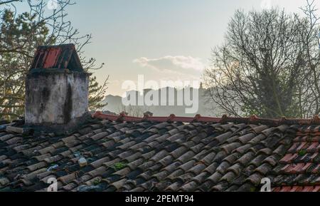 Altmodische Fliesen auf dem Dach eines Landhauses und die Skyline der Stadt im Hintergrund, Safranbolu, Türkei Stockfoto