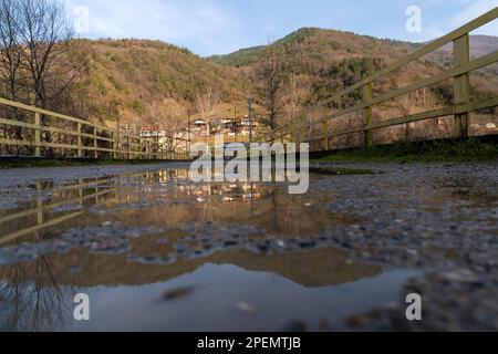 Reflexion des Dorfes im Wasser, das sich auf der Brücke ansammelt, Bartin, Blacksea, Türkei Stockfoto