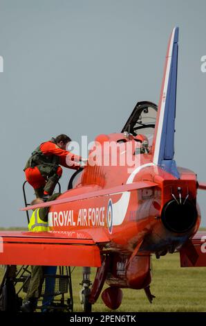 Die Roten Pfeile der Royal Air Force zeigen den Teampiloten Flt Mark Lawson, der an Bord eines Düsenflugzeugs der BAE Hawk T1 klettert, bevor er auf der RAF Scampton, Großbritannien, ausgestellt wird Stockfoto