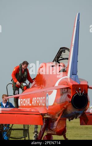 Die Roten Pfeile der Royal Air Force zeigen den Teampiloten Flt Mark Lawson, der an Bord eines Düsenflugzeugs der BAE Hawk T1 klettert, bevor er auf der RAF Scampton, Großbritannien, ausgestellt wird Stockfoto