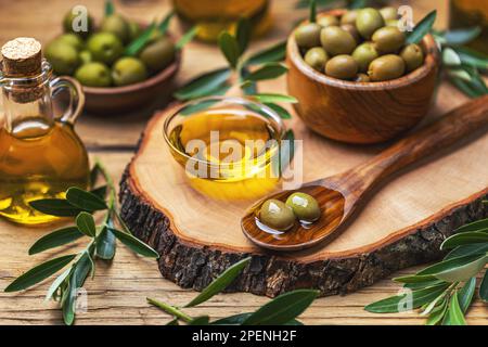 Bio-Olivenöl in Schüssel mit grünen Oliven. Konzept der gesunden mediterranen Ernährung. Stockfoto