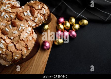 Ostertaubenkuchen, Holzbrett, gestreifte Serviette auf dunklem Betonhintergrund. Einladungs- oder Begrüßungskonzept. Speicherplatz kopieren. Unauffällig Stockfoto