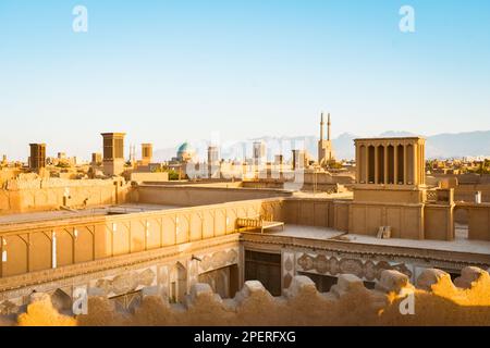 Yazd, Iran - 19. juni 2022: Blick auf Touristen im Café. Windfänger, Kuppeln, Minarette von Yazd bei Sonnenuntergang, Iran Stockfoto