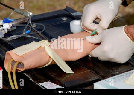 Ein Arzt, der das Einführen eines IV-Katheters praktiziert Stockfoto