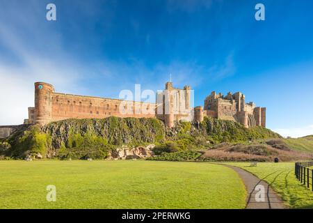 Bamburgh Castle South West Blick von der B1340 Straße südlich des Dorfes Bamburgh. Zeigt einen Teil des Cricketfeldes im Vordergrund an. Stockfoto