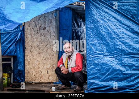 Ein älterer Mann sitzt vor dem Zelt, das er aufgebaut hatte. Nach dem Erdbeben in Kahramanmara? Wurden die Erdbebenopfer dann mit starkem Regen konfrontiert. Stockfoto