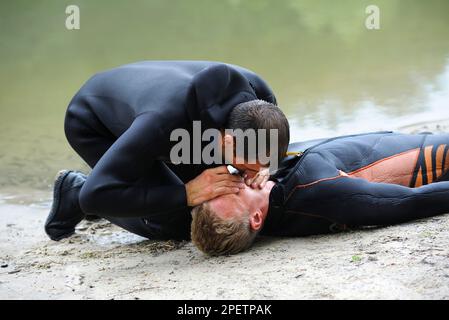 Lektion der künstlichen Atmung. Rettungsschwimmer, der Mund-zu-Mund-Beatmung ertrinkt. Stockfoto