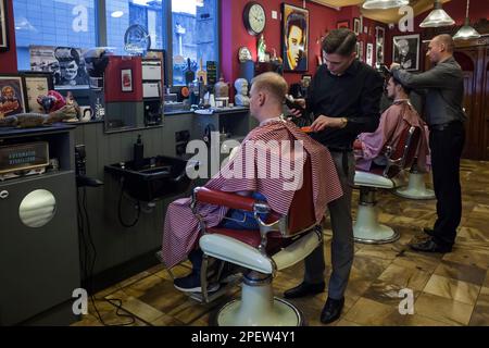 Ich schneide zwei Kunden in einem Friseursalon in Dublin die Haare ab Stockfoto