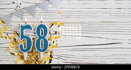 Blaue Festkerze Nummer 58 auf weißem Holzhintergrund. Herzlichen Glückwunsch zum Geburtstag für 58 Jahre. Speicherplatz kopieren. Stockfoto