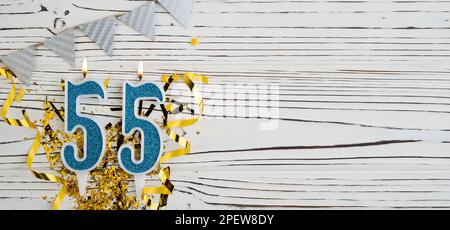 Blaue Festkerze Nummer 55 auf weißem Holzhintergrund. Herzlichen Glückwunsch zum Geburtstag für fünfundfünfzig Jahre. Speicherplatz kopieren. Stockfoto