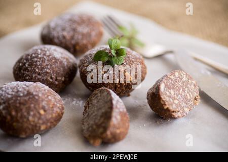 Schokoladen-Süßkuchen aus pürierten Keksen mit Zusatzstoffen auf Backpapier. Stockfoto