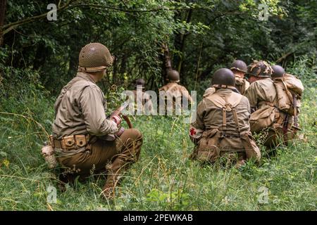 Porabka, Polen – July18, 2020 : Historische Reeneaktoren, die während des Zweiten Weltkriegs als amerikanischer Infanterie-Soldat verkleidet waren, patrouillieren den Wald. Ansicht vom Stockfoto