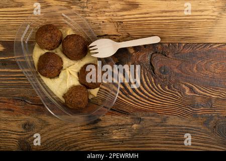 Falafel Balls Top View, gebratene Kichererbsenbälle, traditionelle Falafel in einem Kunststoffbehälter, würzige arabische Halal Food, Falafel auf weißem Hintergrund Stockfoto