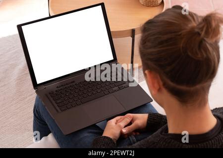 Hochwinkel eines anonymen männlichen Patienten mit Pferdeschwanz, der auf dem Sofa sitzt und spricht, während er während der Sprechstunde Videoanrufe über Laptop führt Stockfoto