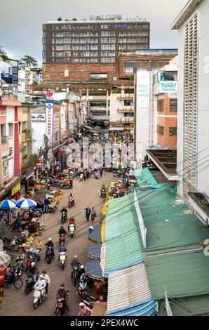 Ein Blick aus der Vogelperspektive auf eine belebte Seitenstraße, die mit vielen Shoppingern auf dem Markt in Dalat, Vietnam, belebt ist. Stockfoto