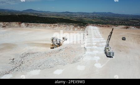 Radlader, der Kohle auf Lkw lädt und auf einer riesigen Bergbaustelle arbeitet. Stockfoto