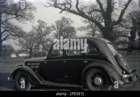 1955, historisch, eine Familie auf einem Autofahrtag, besuchen Windsor Great Park, Berkshire, England, in ihrem Auto der Epoche, einem Ford Perfect oder möglicherweise Anglia. Im Nachkriegs-Britannien war Autovermietung ein Luxus und eine Reise auf dem Land oder an die Küste ein besonderes Ereignis für eine Familie. Stockfoto