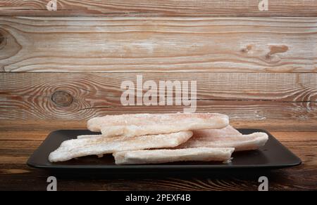 Gefrorener Fisch auf schwarzem Isolat, Weißdorschfilet, gefrorenes Seehechtfilet, gefrorenes Pollackfleisch auf weißem Hintergrund Stockfoto