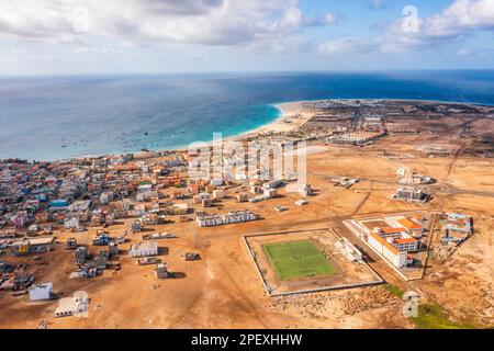 Weiter Blick aus der Vogelperspektive auf Santa Maria mit den Resorts auf der rechten Seite, afrikanisches Dorf auf der linken Seite und Sportfeld in der Mitte, Sal, Kap Verde Inseln, AF Stockfoto