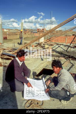 Bolivien, La Paz. Architekt und Baumeister prüfen den Bauplan auf einer Baustelle. Stockfoto
