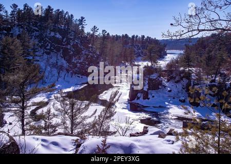 St. Croix River und Angle Rock im Interstate State Park an einem sonnigen Wintertag in Taylors Falls, Minnesota, USA. Stockfoto