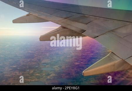 Sun County Airlines Flug über Minnesota USA kurz nach dem Start vom MSP Flughafen mit regenbogenfarbenen Reflexionen; Land von 10.000 Seen. Stockfoto