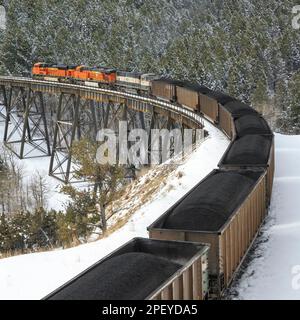 Im Winter in der Nähe von Austin, montana, fährt der Zug Kohle über den Stützpunkt unterhalb des mullan-Passes Stockfoto