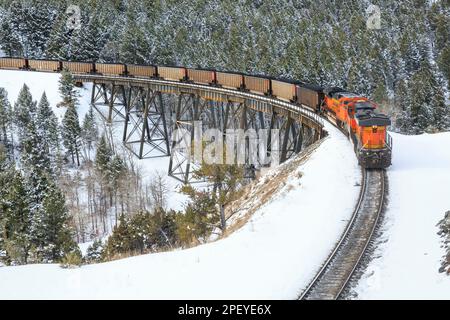 Im Winter in der Nähe von Austin, montana, fährt der Zug Kohle über den Stützpunkt unterhalb des mullan-Passes Stockfoto