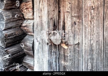 Rostiges Metallschloss an einer alten Holztür Stockfoto