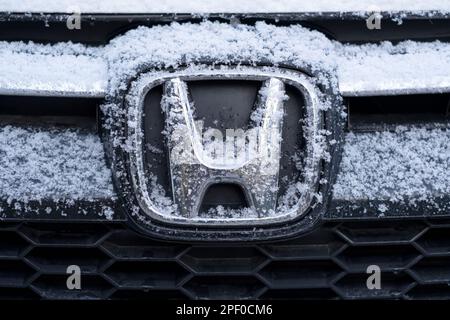 Prag, CZ, 29. November 2021: Details des vorderen Logos von Honda auf dem im Winter bedeckten Fahrzeuglogo. Schließen. Editorial Stockfoto
