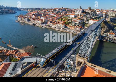 Porto, Portugal - 02. März 2023: Blick auf das historische Viertel Ribeira am Ufer des Douro-Flusses in der Altstadt und auf die Luis-I-Brücke, Porto, Po Stockfoto